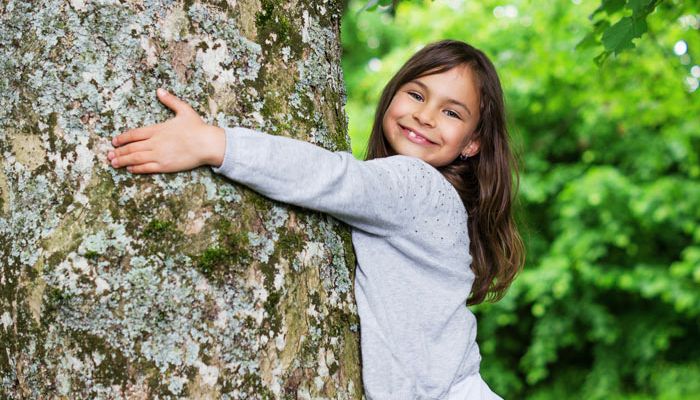Mädchen umarmt Baum